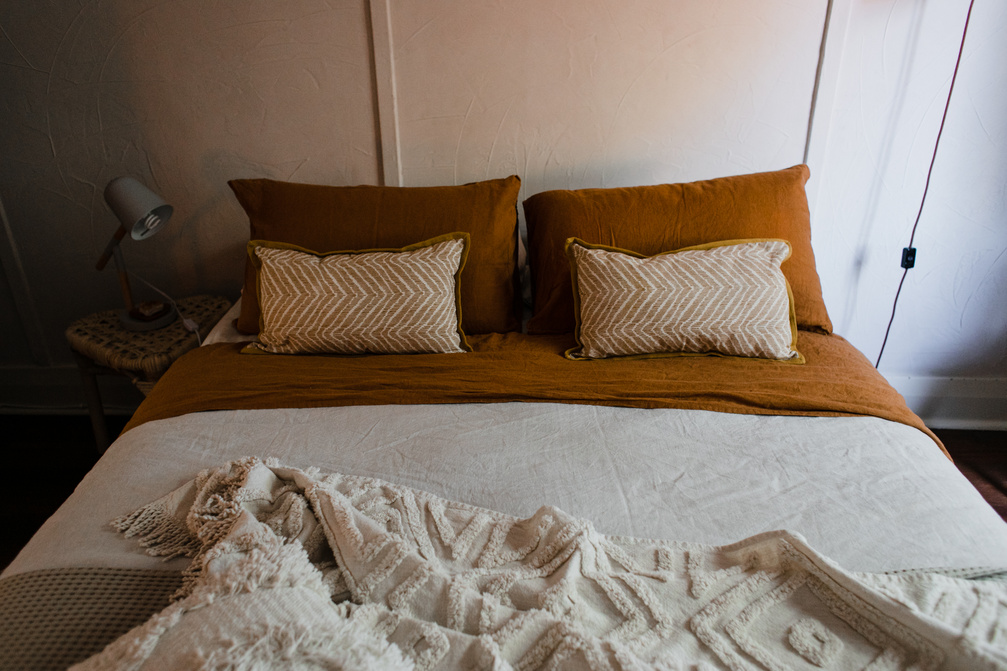 Bed with Brown Pillows and Brown and White Linen